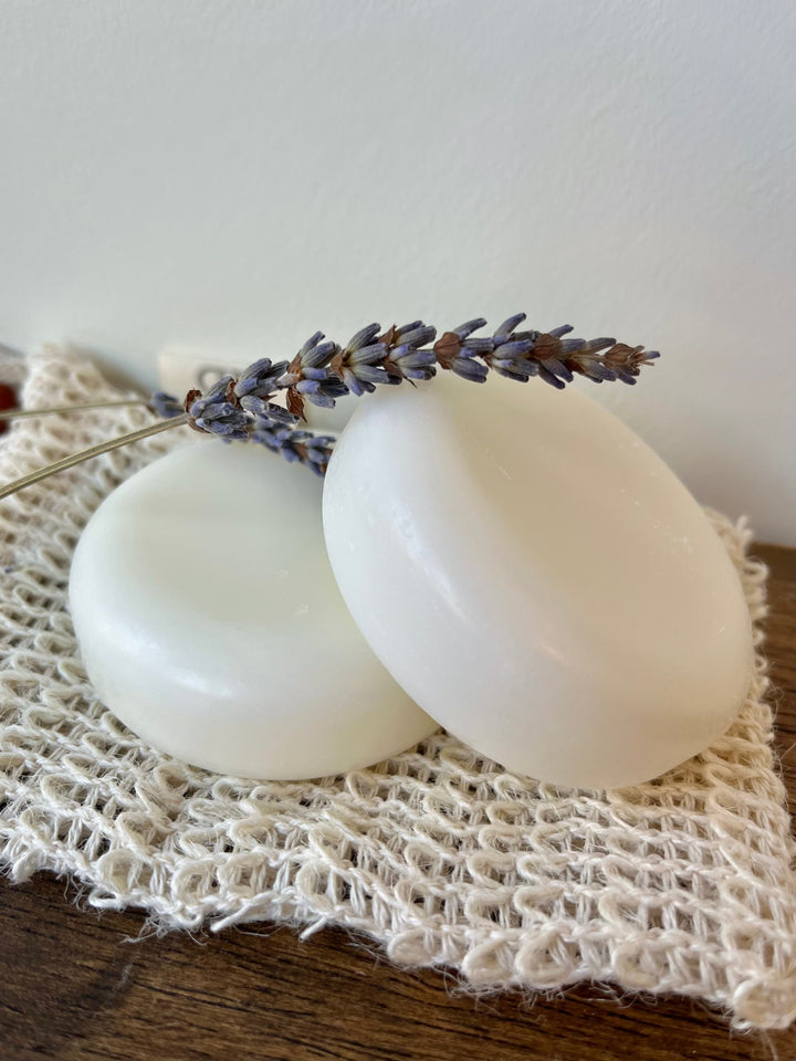 Solid conditioner bar pair: white round disks on a woven cloth with lavender sprigs