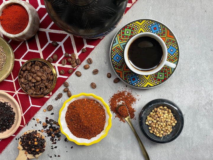 Coffee spice blend assortment: bowls of beans and ground spices on table.