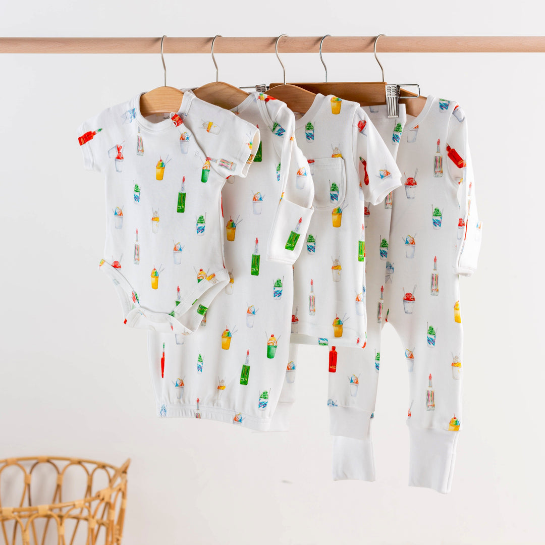 Kids pajama sets hanging together, white with colorful popsicle print, matching pieces