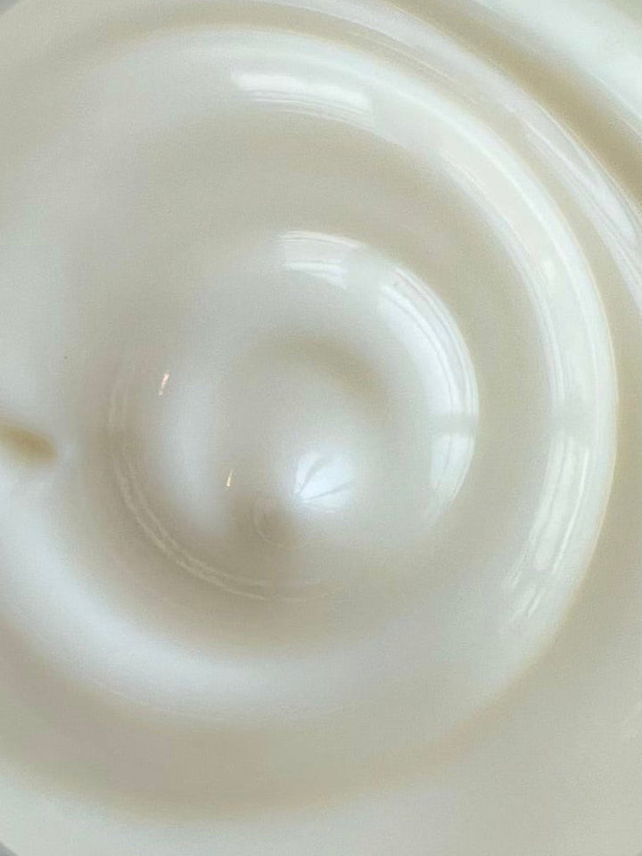 Thick white face cream swirl, close-up texture on skin