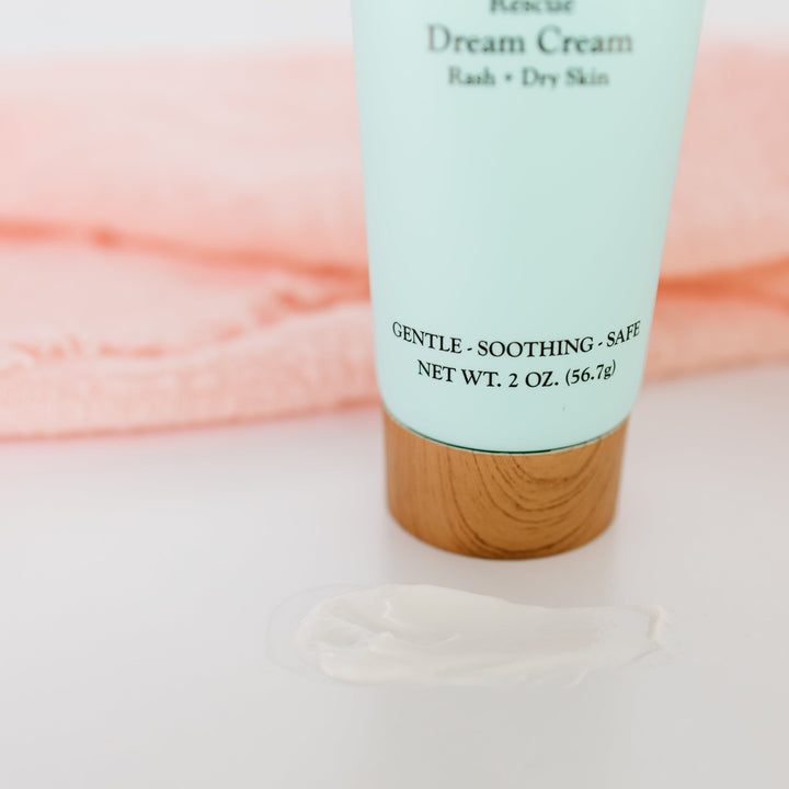 Close-up light blue baby cream tube with wood base; Gentle–Soothing–Safe text visible