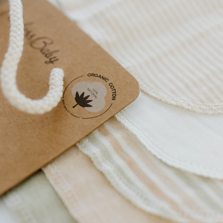 Organic cotton washcloths with kraft tag label; cream cloth with stitched edge.