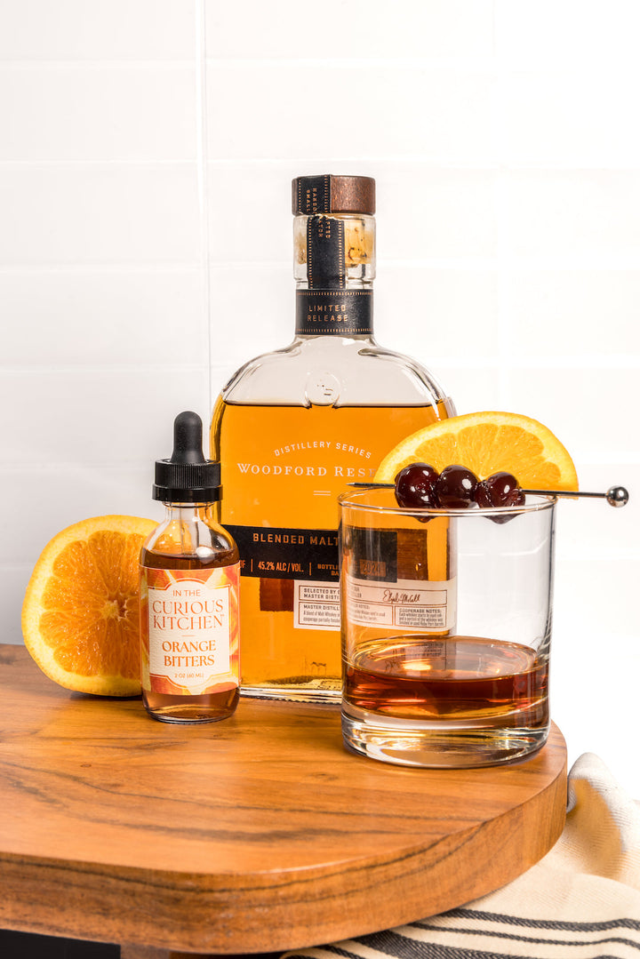 Orange bitters bottles with black droppers and amber liquid, clear glass and labeled containers.