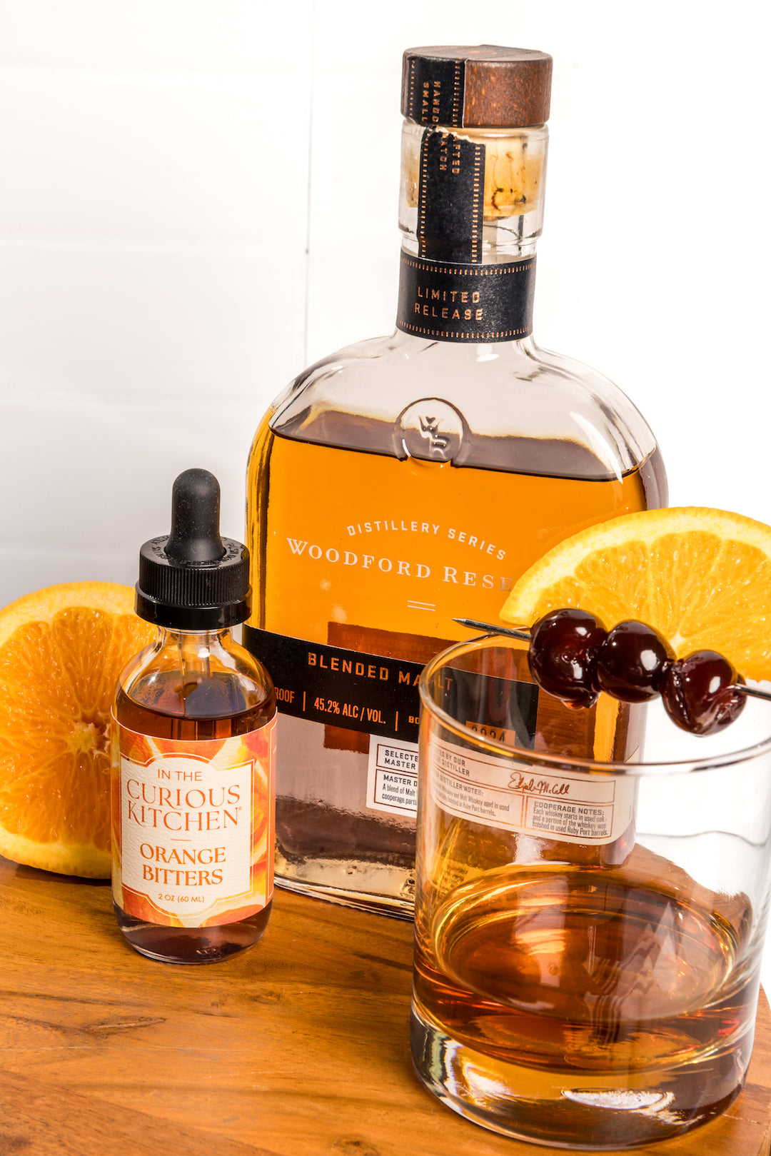 Orange bitters bottles with black droppers and amber liquid, clear glass bottles and citrus.