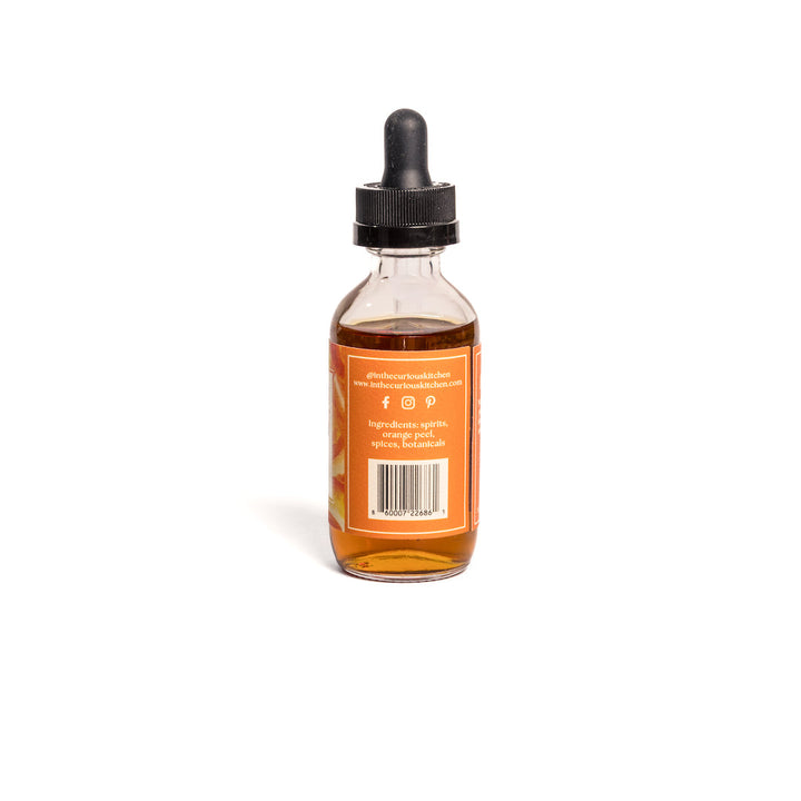 Orange bitters bottle with black dropper, amber liquid, barcode label on back.