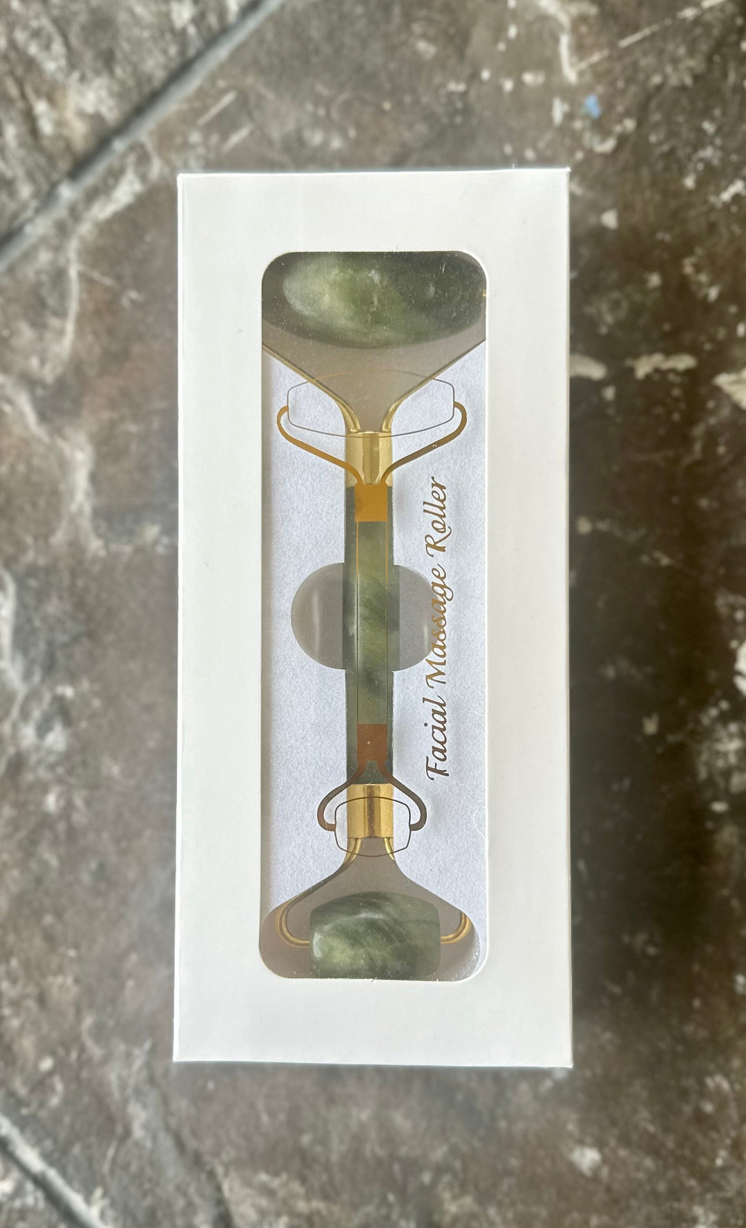 Jade facial roller in retail box with two green stones and gold-tone frame
