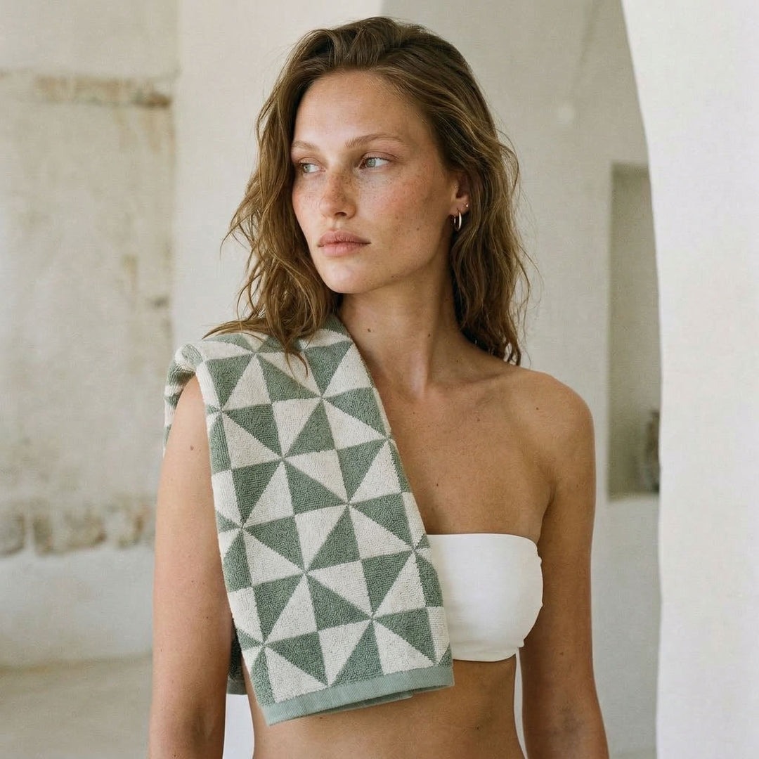 Green and light gray geometric cotton towel draped over a model’s shoulder.