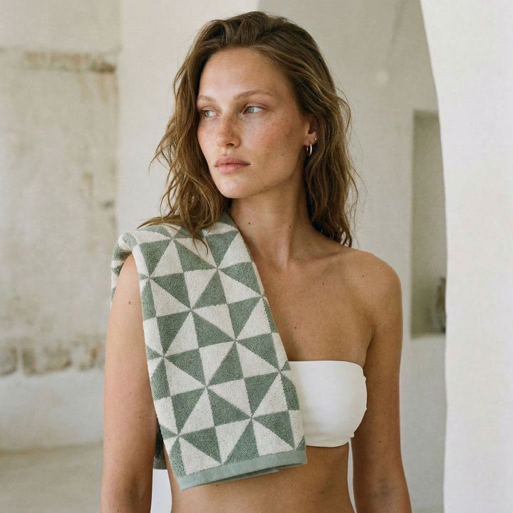 Green and light gray geometric cotton towel draped over a model’s shoulder.