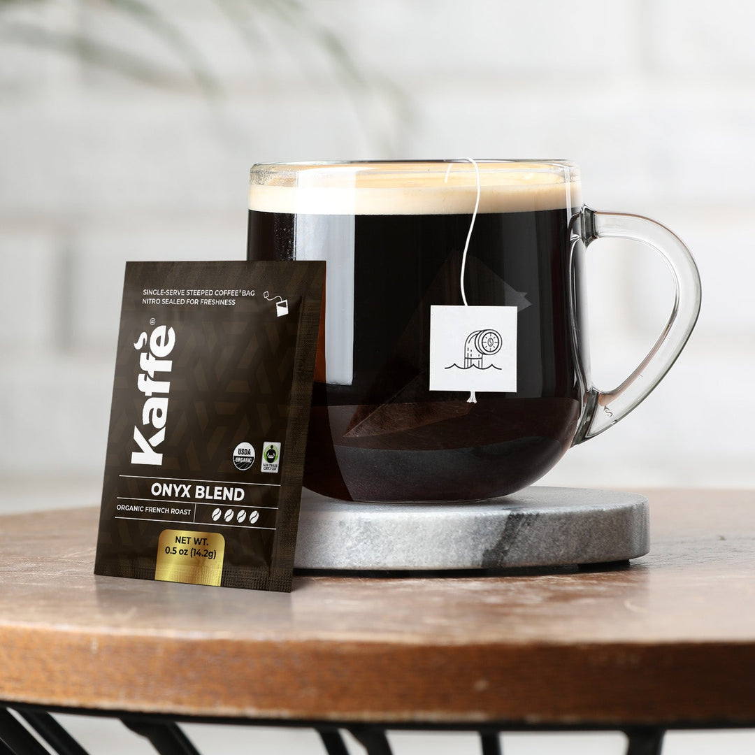 Onyx Blend coffee steeped bag beside a glass mug of dark coffee