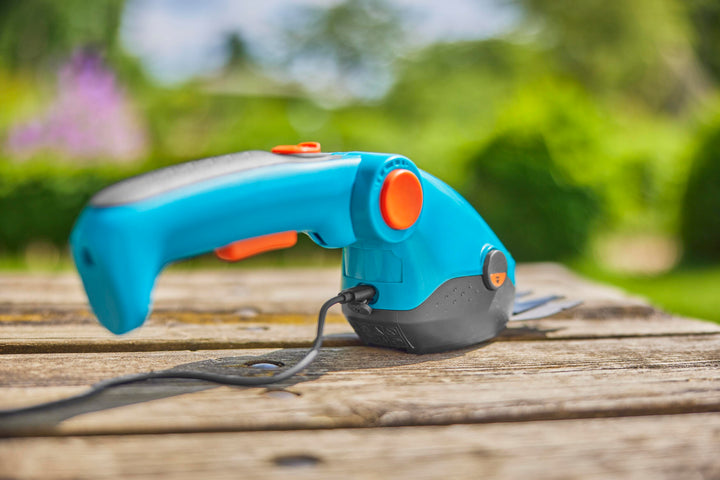 Teal cordless garden shears with orange button and black blade guard