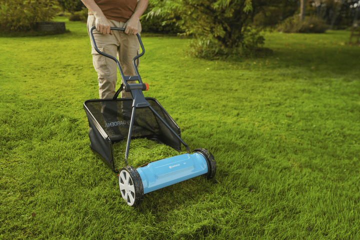 Black grass catcher bag on a lawn mower, open top with rigid support frame.
