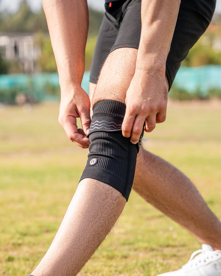 Black compression knee sleeves with ribbed knit and logo at cuff