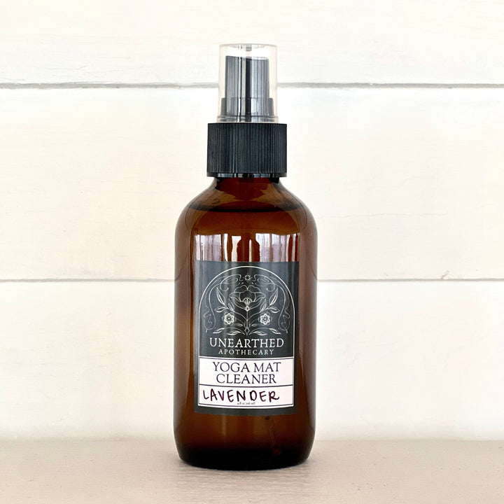 Yoga mat cleaning spray bottle with lavender label, amber glass and black mist sprayer