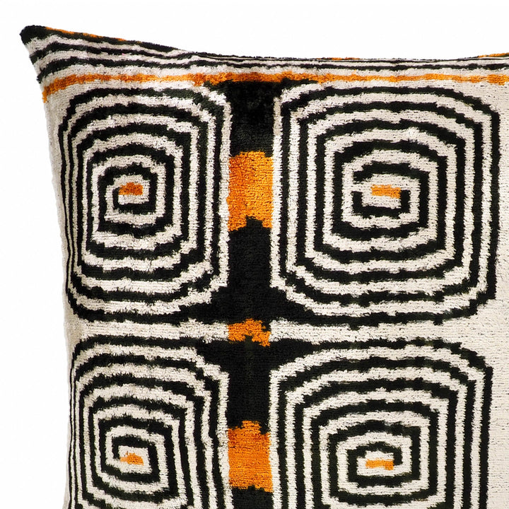 Close-up of cream and black labyrinth ikat velvet pillow pattern with orange crosses