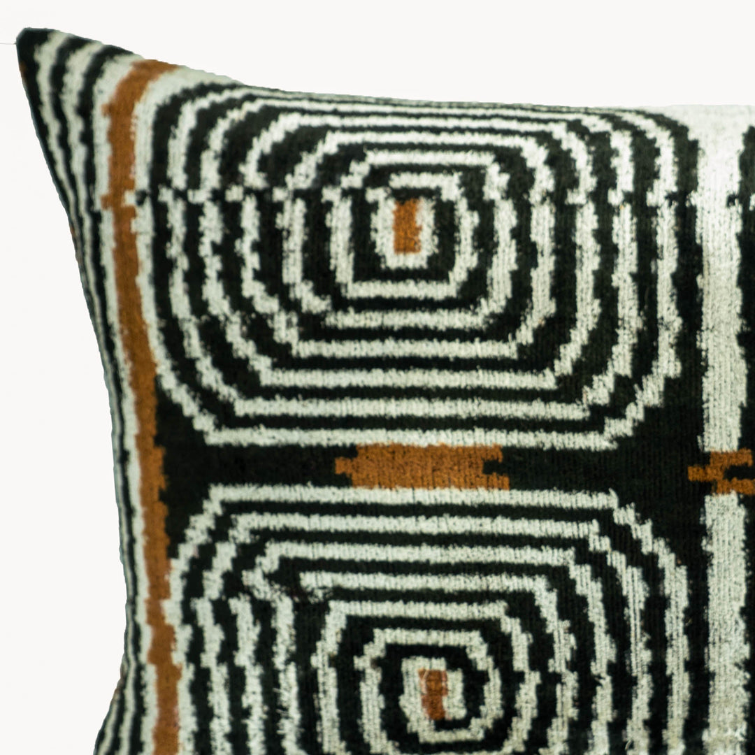 Ikat throw pillow cover close-up, black/white concentric swirl motifs with brown dots