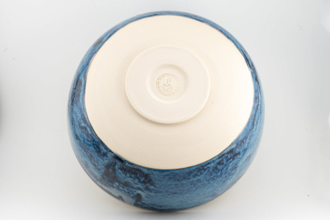 Ceramic bowl top view with cream interior and deep blue speckled glaze