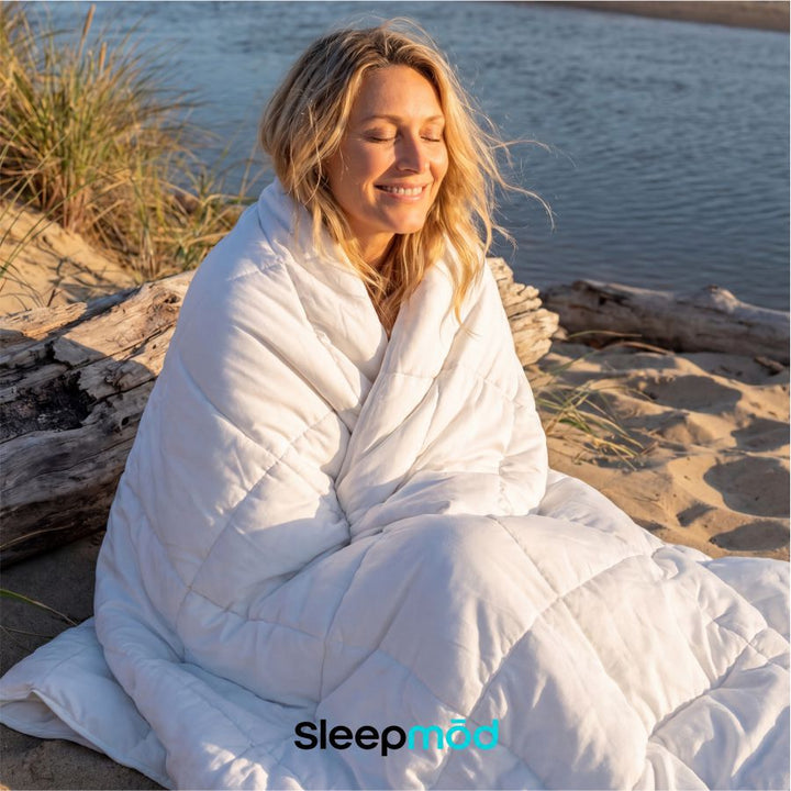 White cooling comforter wrapped around a seated person