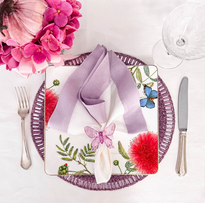 Lilac linen napkins with double-sided border, folded over center on table setting