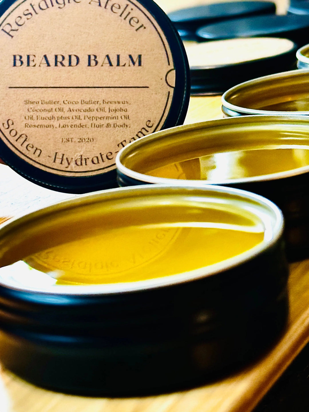 Beard balm tin with open lid and yellow-gold balm inside