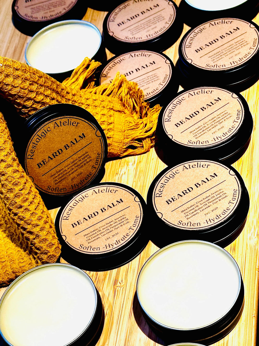 Assorted beard balm tins with white lids, round black containers