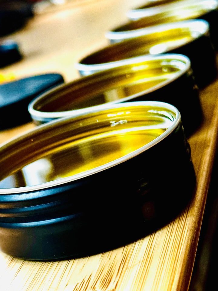 Beard balm jars with open lids and glossy yellow balm