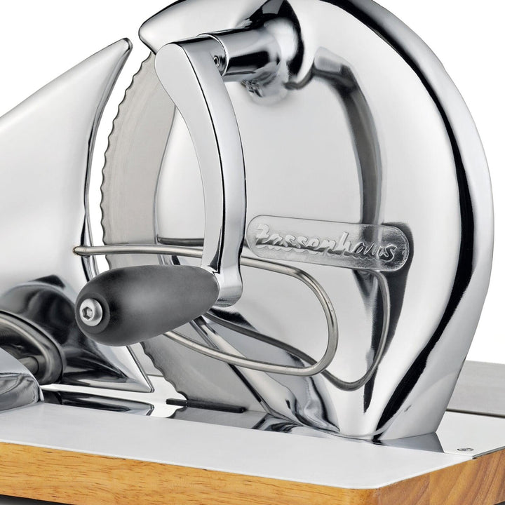 Close-up of chrome bread slicer blade housing with embossed brand mark and black handle