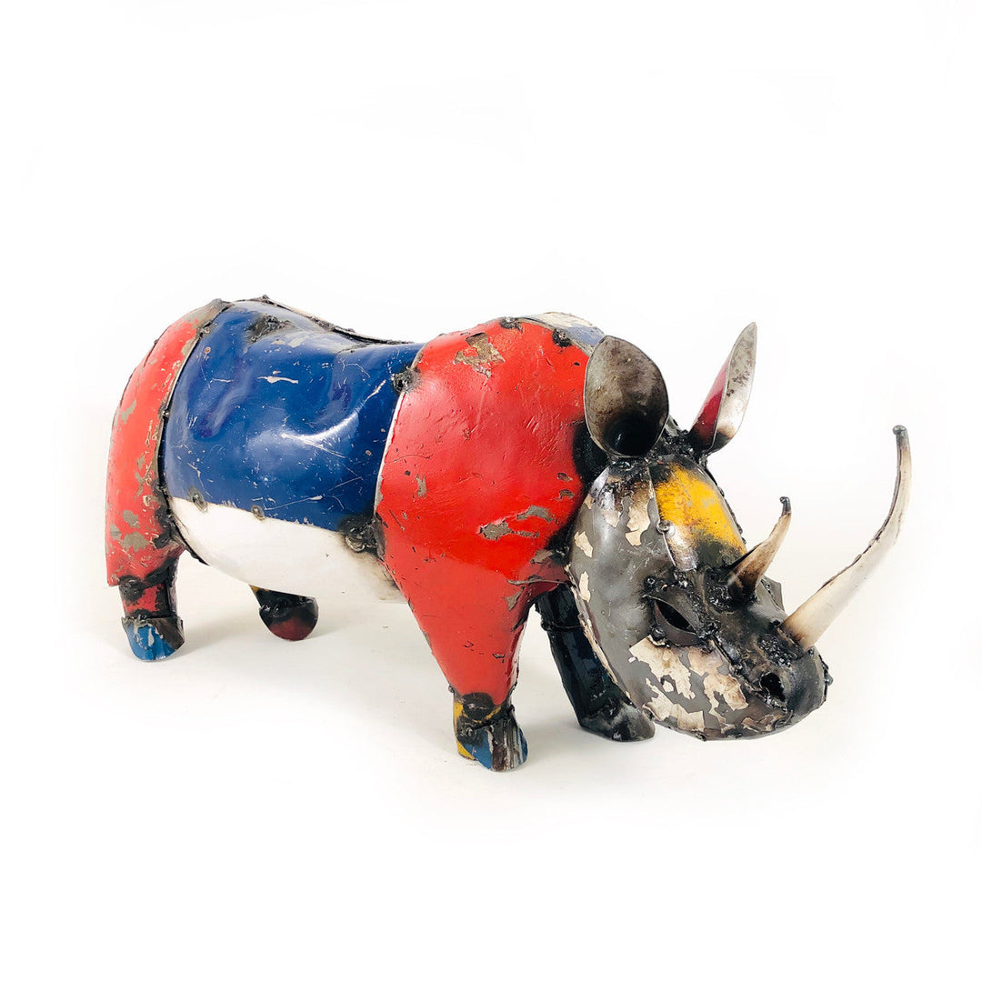 Recycled metal rhino sculpture, side view, red and blue body with black horns and legs
