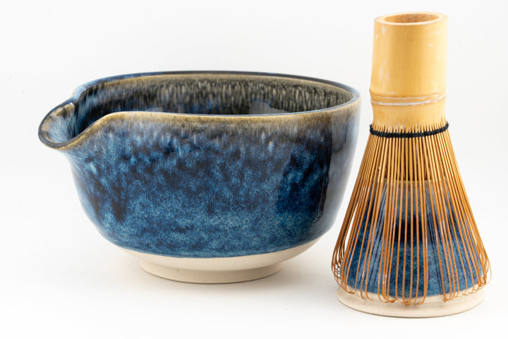 Blue ceramic matcha bowl with side handle and matching whisk holder with bamboo bristles