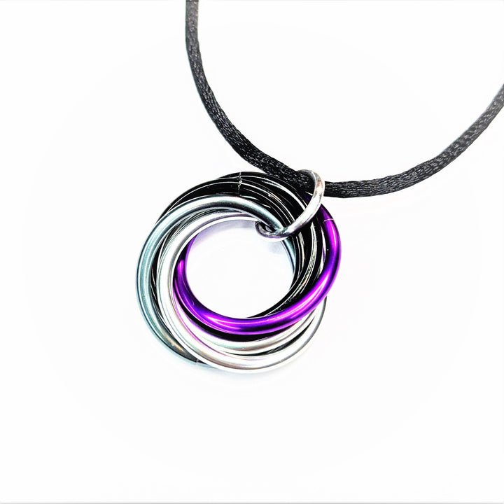 Multiring fidget necklace with black cord and purple-silver iridescent hoop pendant