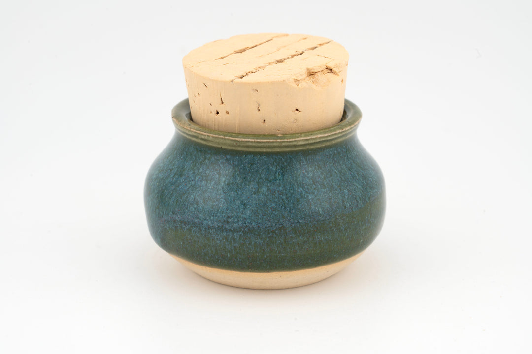 Mini corked jar with dark green ceramic glaze and cork lid.