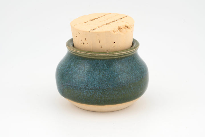 Mini corked jar with dark green ceramic glaze and cork lid.