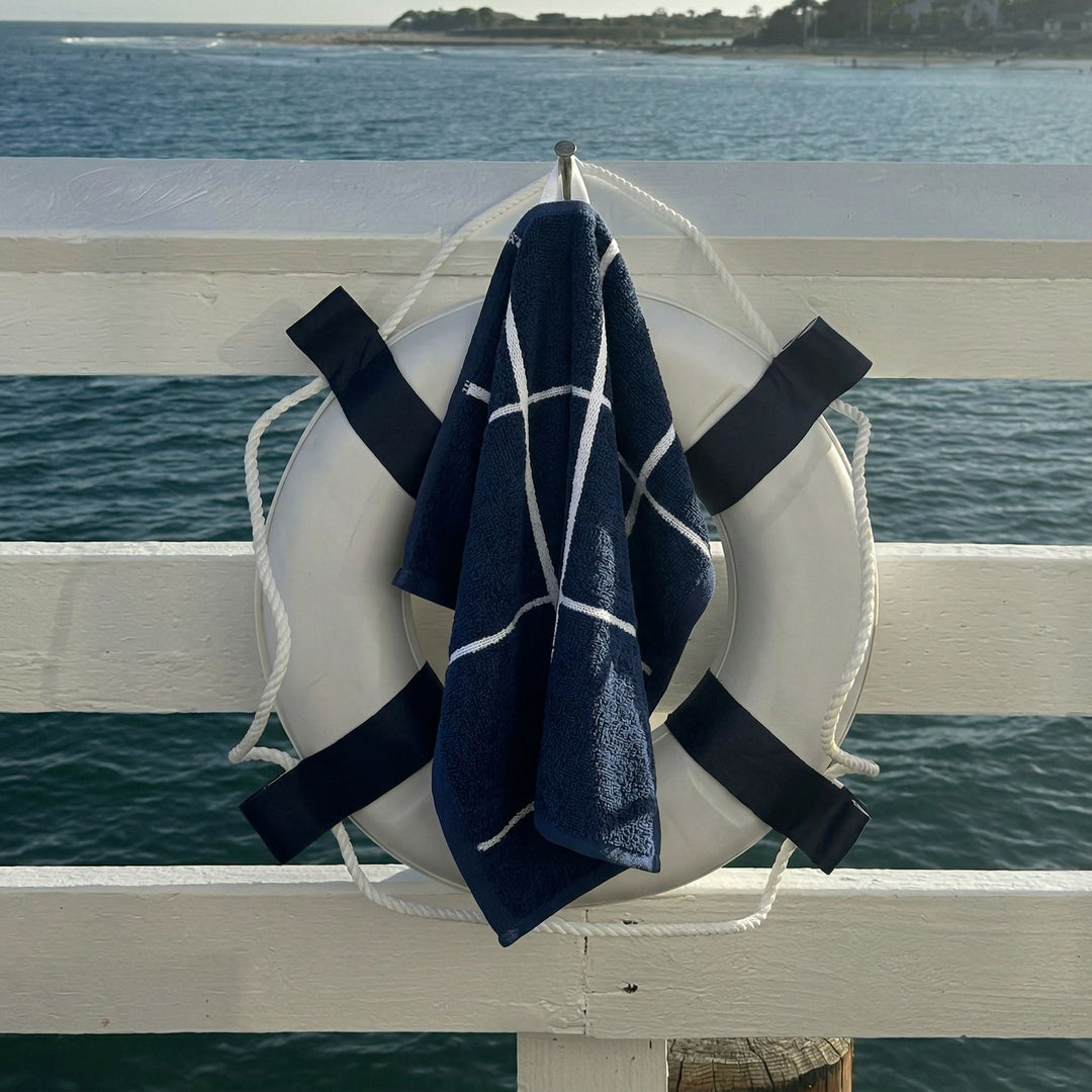 Navy cotton towel with white stripes draped on a lifebuoy ring