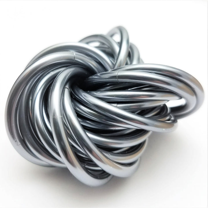 Swirled metallic fidget stress ball, silver-gray glossy loops with a raised curved strand