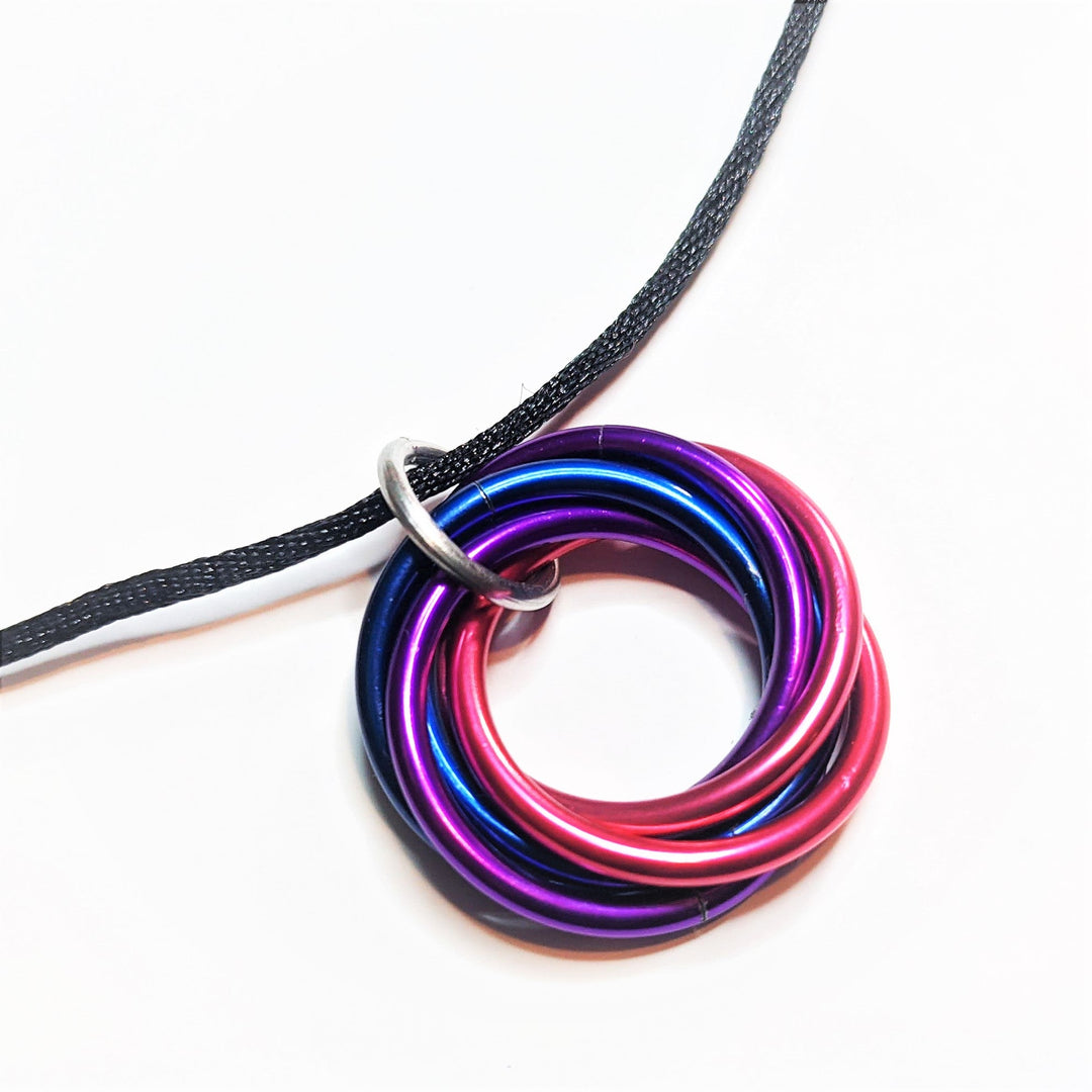 Multiring fidget necklace with black cord and purple-pink iridescent hoop pendant