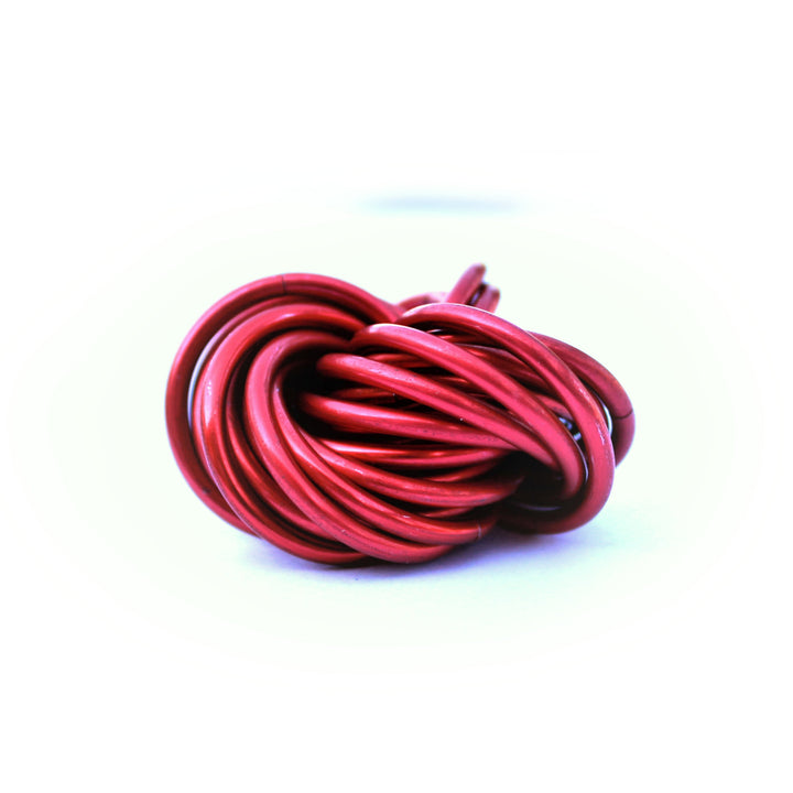 Pink and dark red metallic stress ball fidget toy, twisted looped cords ball.