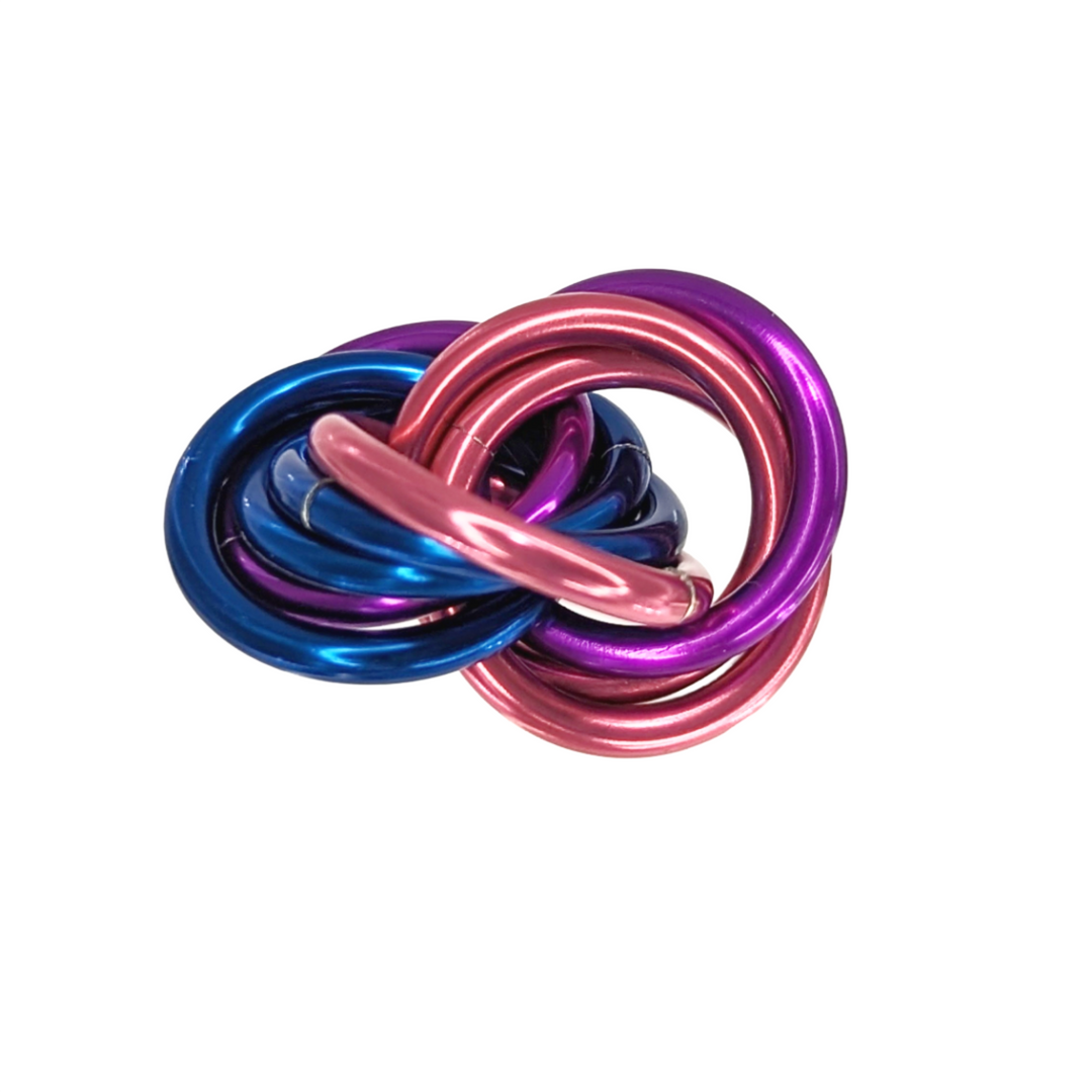 Shiny multicolor fidget stress balls in a clear cup with pink, blue, purple, and gold coils