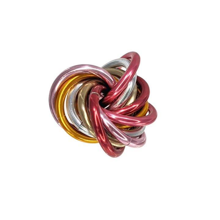 Shiny multicolor fidget stress balls in a clear cup with pink, red, gold, and silver coils