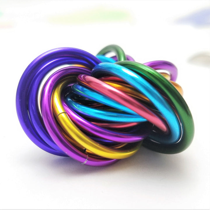 Shiny multicolor ring fidget stress ball, purple blue green rings in a tight swirl