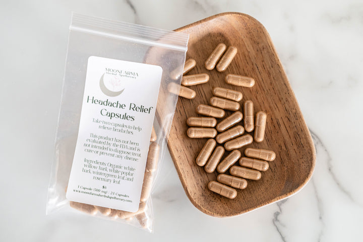 Headache relief capsules in clear pouch with wooden scoop of beige gelatin capsules