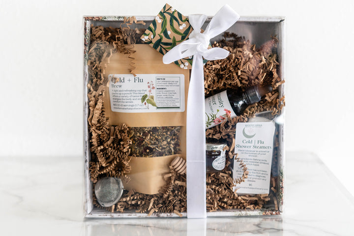 Cold and flu wellness kit gift box with shredded filler, tea pouch, tincture, and supplements