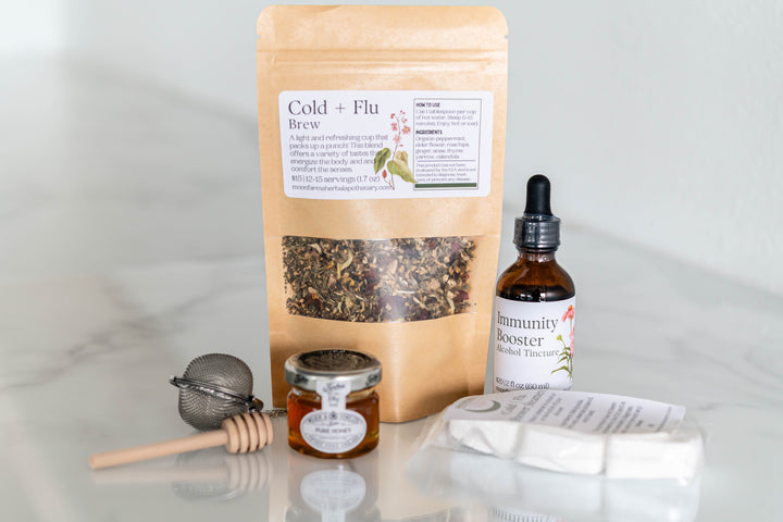 Cold and flu wellness kit with herbal pouch, tincture bottle, small jar, and tea strainer
