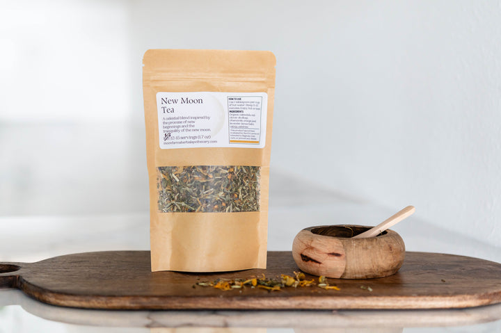 Botanical tea pouch with label and dried herb blend in a wooden scoop
