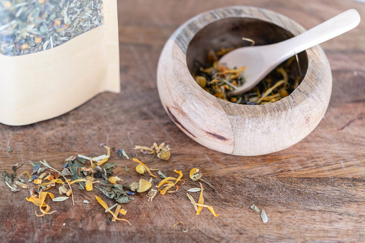 Serving bowl with spoon and loose dried botanical tea herbs