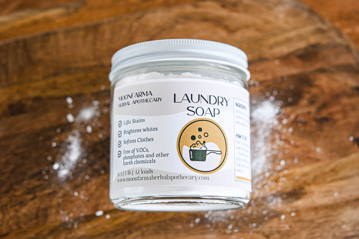 Laundry soap in clear glass jar with white lid, front label with icon