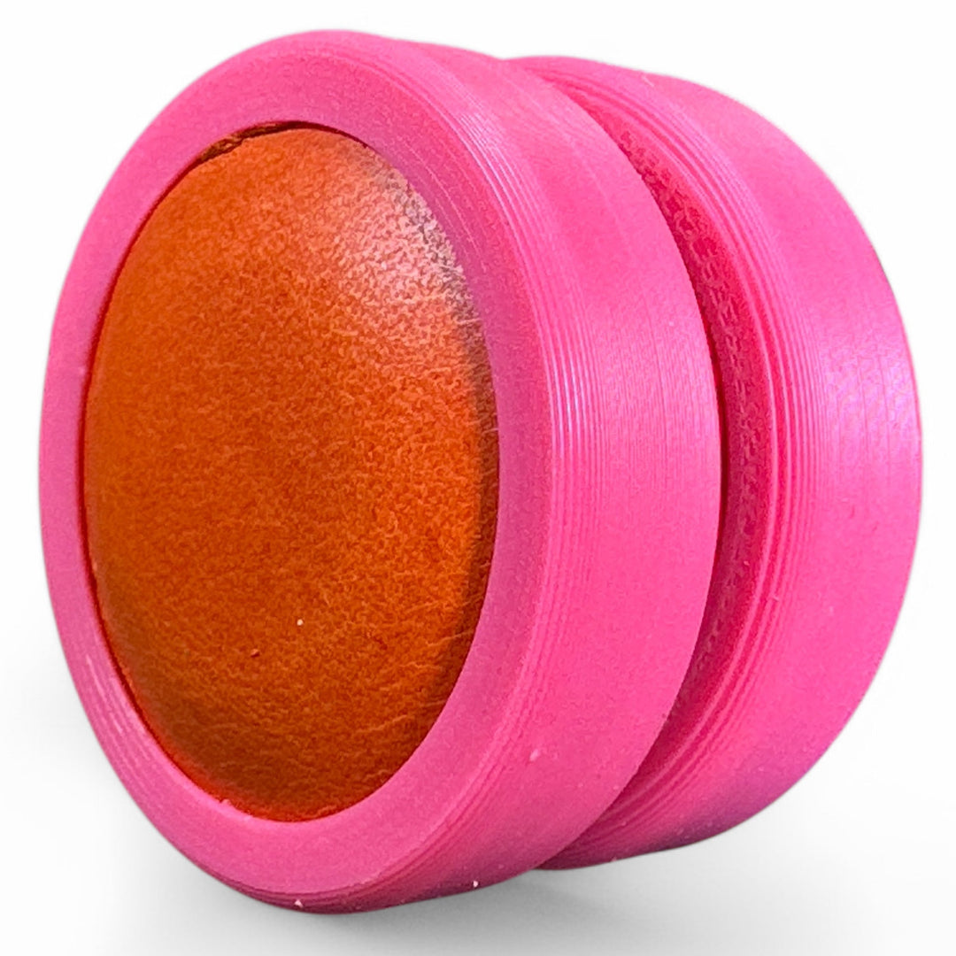 Pink fidget moon toy with orange oval center, two stacked rings