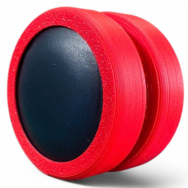 Red fidget moon toy with dark oval center, two stacked rings