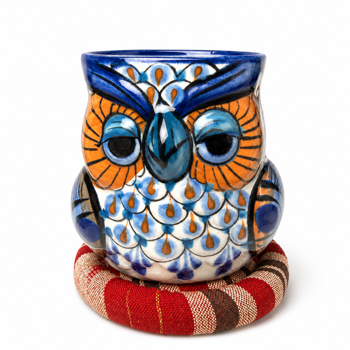Round owl-pattern ceramic mug on a red and tan plaid spiral trivet with rosette center