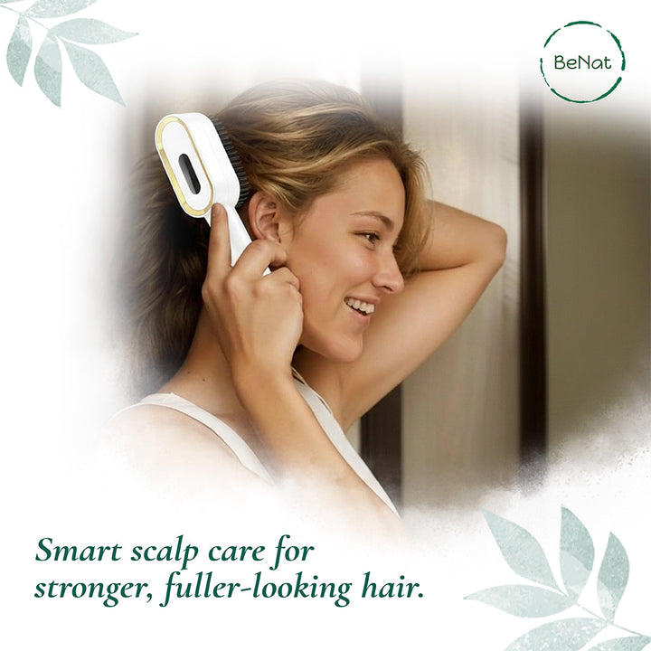 White electric scalp massager brush held to the side of a woman’s head