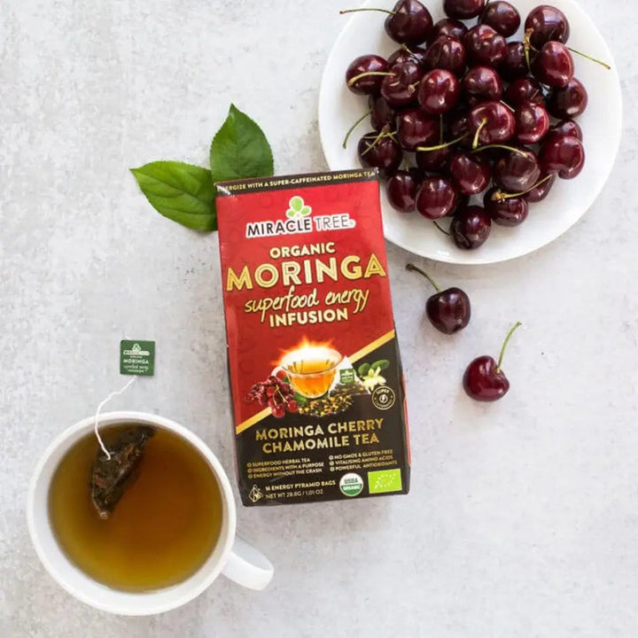 Organic moringa cherry chamomile tea pack with cup and fresh cherries