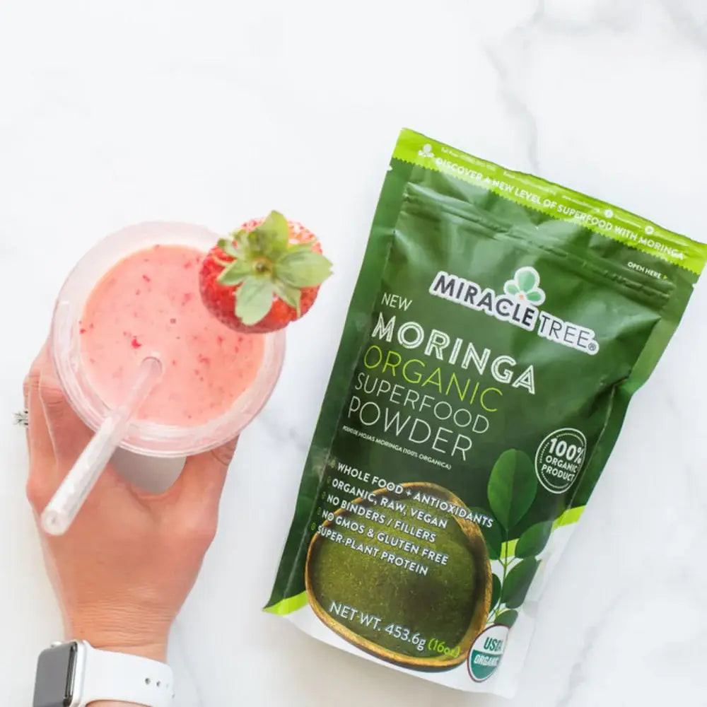 Miracle Tree organic moringa superfood powder pouch with smoothie cup nearby